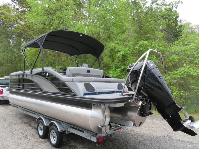Slide: The Image of 2024 Bennington 23RSB pontoon boat with outboard motor on trailer. - 3