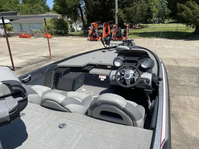 Slide: The Image of 2010 Nitro Z9 boat interior with steering wheel and seating, parked outdoors. - 6