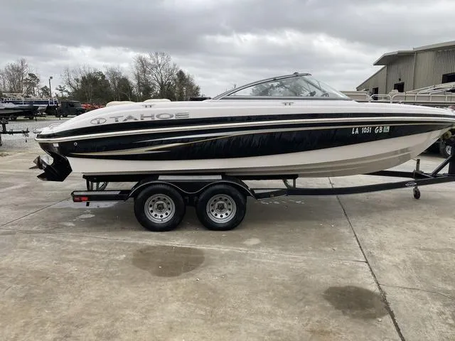 Slide: The Image of 2012 Tahoe Q8SSI boat with white interior, parked outdoors. - 5