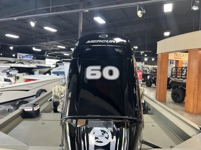 Slide: The Image of 2024 Tracker 1754SC boat in showroom, featuring camouflage seats and steering console. - 3