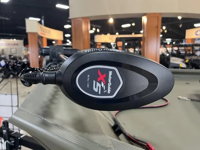 Slide: The Image of 2024 Tracker 1754SC boat with camo seats displayed in a showroom. - 5