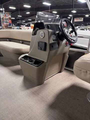 Slide: The Image of 2024 Sun Tracker PARTY BARGE® 16 DLX interior with beige seating and helm. - 5