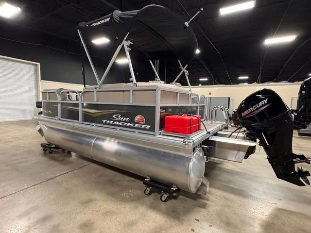Slide: The Image of 2024 Sun Tracker PARTY BARGE® 16 DLX pontoon boat in showroom with Mercury outboard. - 9