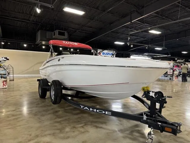 Slide: The Image of 2024 Tahoe T18 boat on trailer in showroom with red canopy. - 1