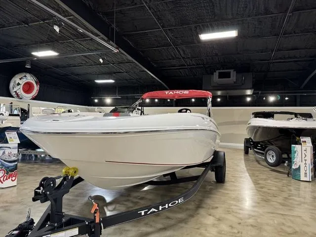 Slide: The Image of 2024 Tahoe T18 boat displayed in showroom with red canopy and trailer. - 2