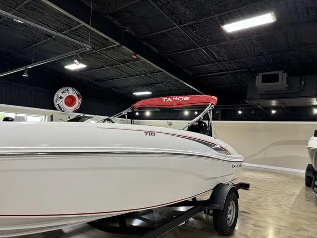 Slide: The Image of 2024 Tahoe T18 boat with red canopy in showroom, side view. - 3