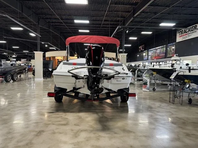 Slide: The Image of 2024 Tahoe T18 boat with red canopy displayed in showroom. - 6
