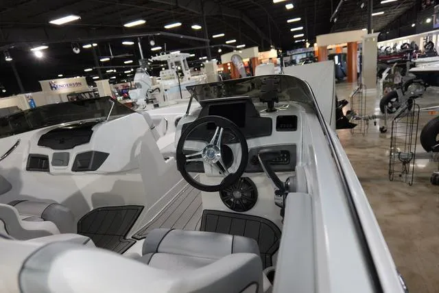 Slide: The Image of 2024 Tahoe TAHOE210SILJ boat interior at a showroom, featuring steering wheel and seating. - 3