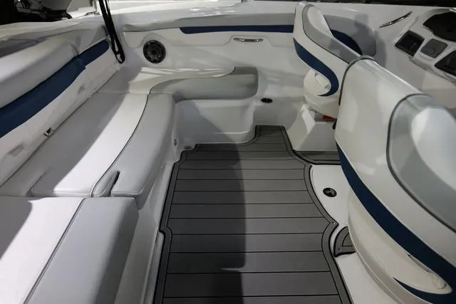 Slide: The Image of 2024 Tahoe TAHOE210SILJ boat interior with white and blue seating and gray flooring. - 6