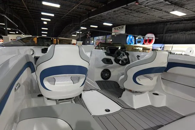 Slide: The Image of 2024 Tahoe TAHOE210SILJ boat interior with white and blue seating, steering wheel, and dashboard. - 7