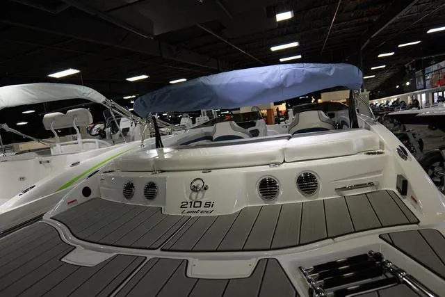 Slide: The Image of 2024 Tahoe TAHOE210SILJ boat with blue canopy displayed indoors. - 8