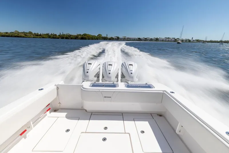 Slide: The Image of 2021 Contender 39FA Fish Around boat with triple outboard engines cruising on water. - 25