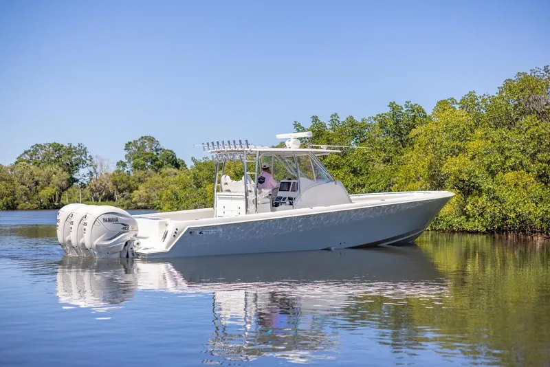 Slide: The Image of 2021 Contender 39FA Fish Around boat on calm water with lush greenery. - 4