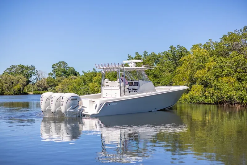 Slide: The Image of 2021 Contender 39FA Fish Around boat on calm water with triple outboard engines. - 5