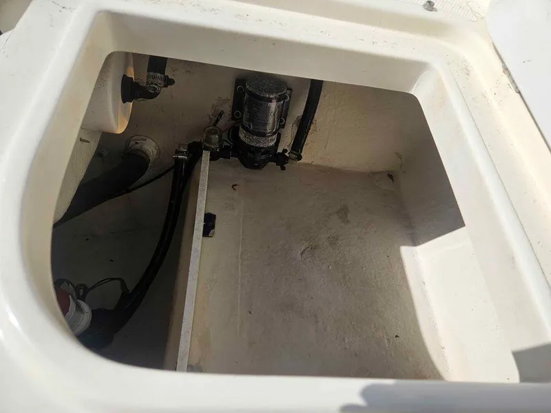 Slide: The Image of 2014 Key Largo 2100 boat compartment with pump and hoses. - 19