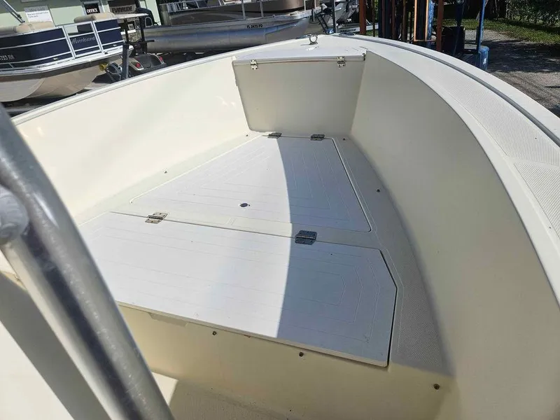 Slide: The Image of 2014 Key Largo 2100 boat interior with storage compartments, docked near other boats. - 26