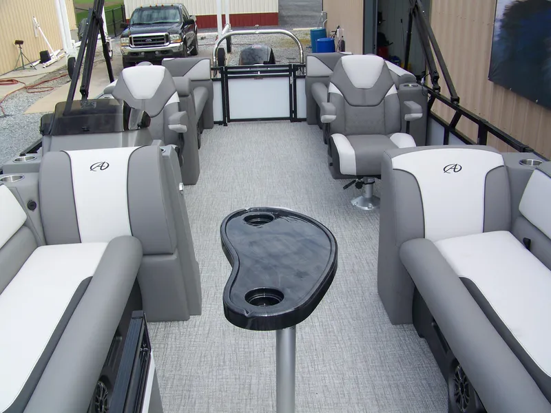 Slide: The Image of 2024 Avalon VENTURE 85 QL pontoon boat interior with luxurious seating and central table. - 5