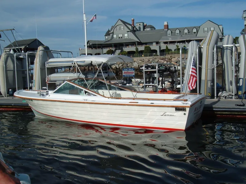 Slide: The Image of 1978 Lyman 24 Sportsman boat docked at marina with American flag. - 11