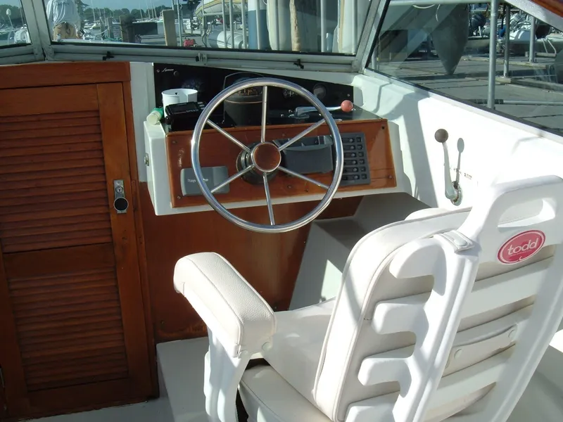 Slide: The Image of 1978 Lyman 24 Sportsman boat cockpit with steering wheel and white captain's chair. - 5