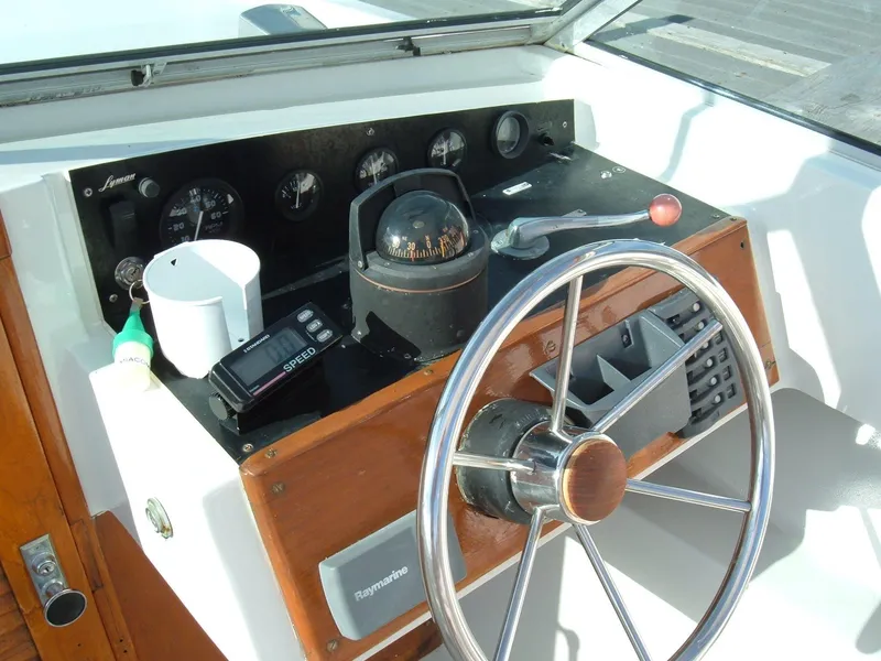 Slide: The Image of 1978 Lyman 24 Sportsman boat dashboard with steering wheel and navigation instruments. - 6