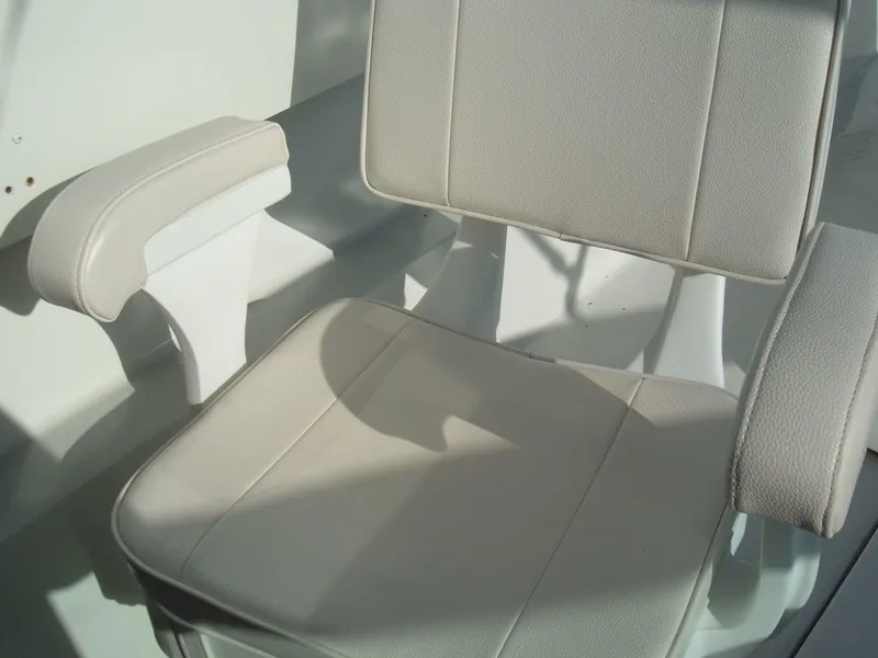 Slide: The Image of 1978 Lyman 24 Sportsman boat seat with white upholstery and armrests. - 8