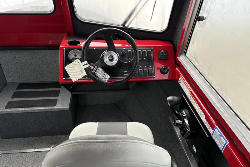Slide: The Image of 2024 Spartan 240 Maximus Pro boat interior with steering wheel and control panel. - 12