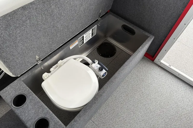 Slide: The Image of 2024 Spartan 240 Maximus Pro interior with built-in toilet and storage compartment. - 16