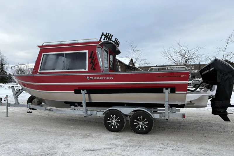 Slide: The Image of 2024 Spartan 240 Maximus Pro boat on trailer, red and silver design, parked on snowy ground. - 2