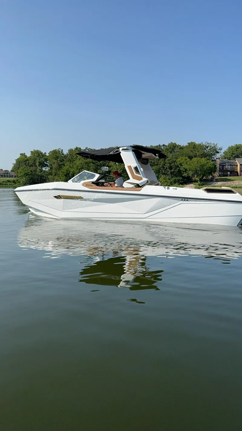 Slide: The Image of 2024 Nautique G25 Paragon boat on calm water, clear sky background. - 4