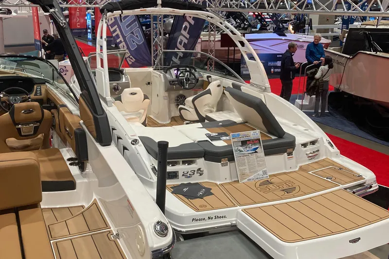 Slide: The Image of 2024 Chaparral 23 Surf boat on display at a boat show. - 2