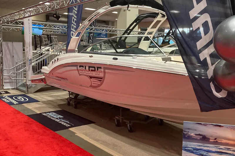 Slide: The Image of 2024 Chaparral 23 Surf boat displayed at an indoor boat show. - 4