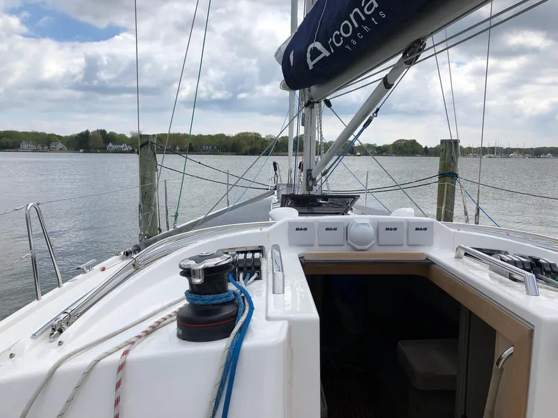 Slide: The Image of 2020 Arcona 435 yacht docked, showcasing deck and rigging against a serene waterfront backdrop. - 21