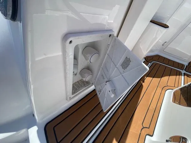 Slide: The Image of 2019 Monterey 295 boat deck with open storage compartment and teak flooring. - 10