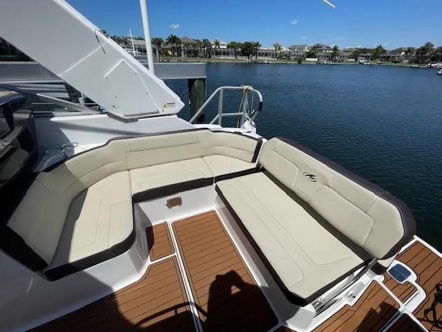 Slide: The Image of 2019 Monterey 295 boat with beige seating, docked by a scenic waterfront. - 12