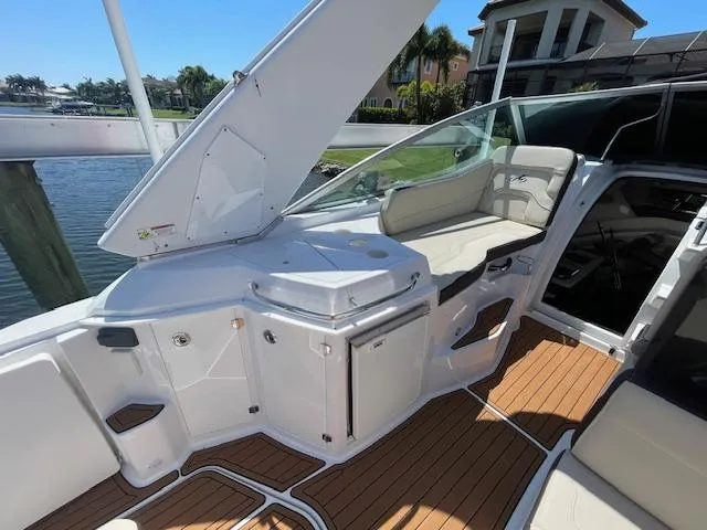 Slide: The Image of 2019 Monterey 295 boat interior with seating, open hatch, and wooden deck. - 13