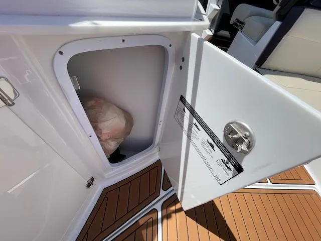 Slide: The Image of Open storage compartment on 2019 Monterey 295 boat with wooden flooring. - 16
