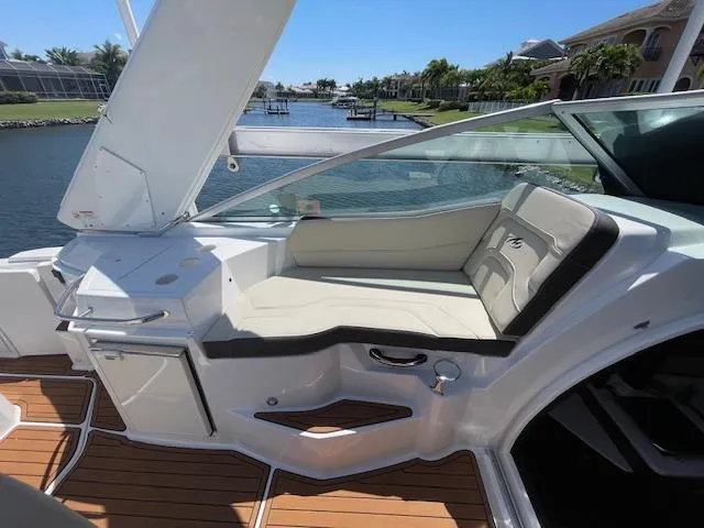 Slide: The Image of 2019 Monterey 295 boat interior with white seating, wooden flooring, and waterfront view. - 19