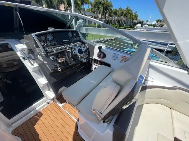 Slide: The Image of 2019 Monterey 295 boat cockpit with steering wheel, control panel, and cushioned seating. - 20