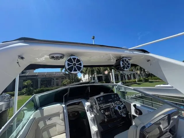 Slide: The Image of 2019 Monterey 295 boat interior with speakers and control panel under clear blue sky. - 28