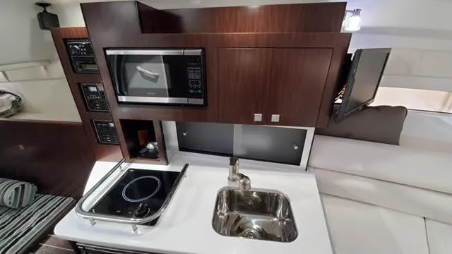 Slide: The Image of Modern kitchen in 2019 Monterey 295 boat with stove, sink, and microwave. - 33