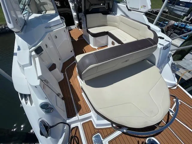 Slide: The Image of 2019 Monterey 295 boat interior with beige seating and wood accents. - 8