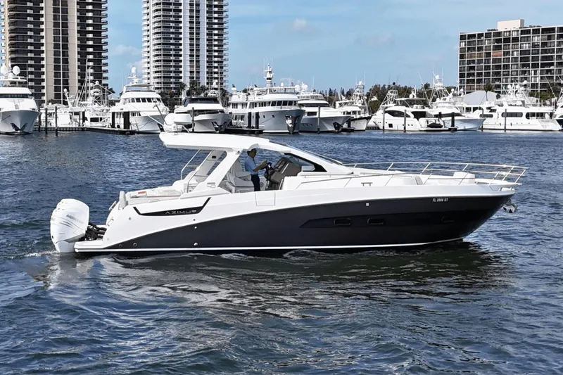 Slide: The Image of Azimut 40 Verve 2020 yacht cruising in a marina with skyscrapers in the background. - 2
