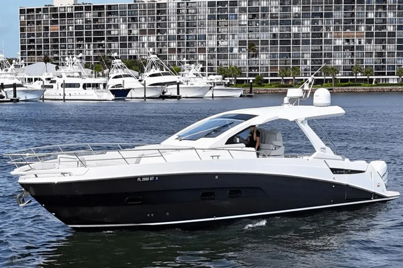Slide: The Image of 2020 Azimut 40 Verve yacht cruising in a marina with modern buildings in the background. - 8