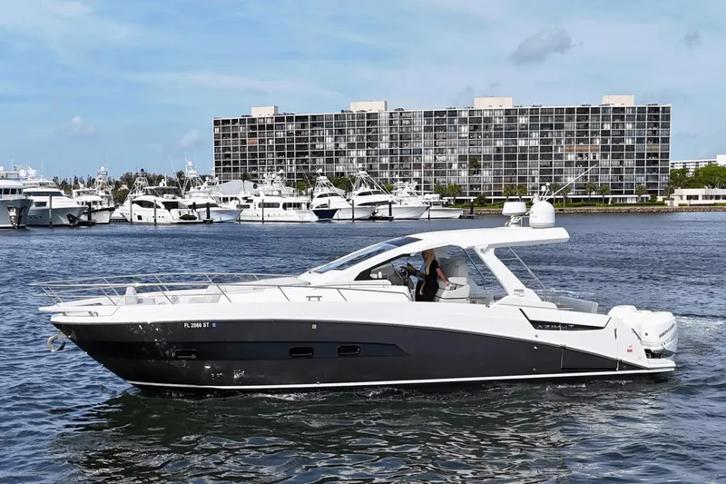 Slide: The Image of 2020 Azimut 40 Verve yacht cruising near a marina with modern buildings in the background. - 9