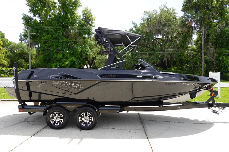 Slide: The Image of 2019 Axis T22 boat on trailer, black exterior, parked outdoors. - 4