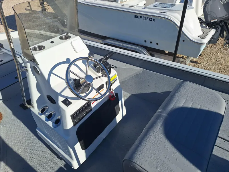 Slide: The Image of 2024 SeaArk 210 Bayrunner boat console and seating area. - 3