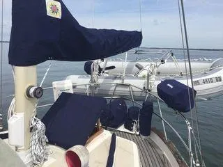 Slide: The Image of 1976 Westsail Ketch sailboat with covered deck, moored on calm water. - 10