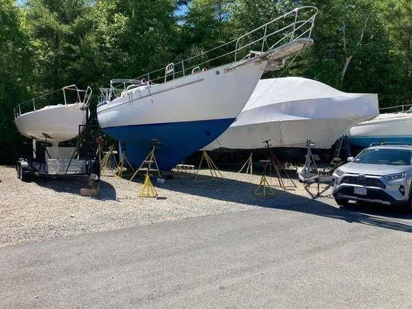 Slide: The Image of 1976 Westsail Ketch sailboat on stands, surrounded by trees and parked vehicles. - 12