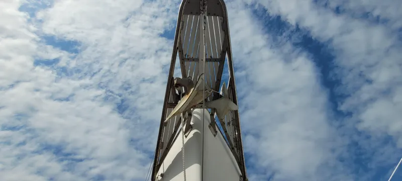 Slide: The Image of 1976 Westsail Ketch mast against a cloudy blue sky. - 17