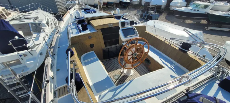 Slide: The Image of 1976 Westsail Ketch sailboat cockpit with wooden wheel and navigation equipment. - 23